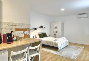 Schlafzimmer mit einem Bett und einem Schreibtisch mit Stühlen in der Unterkunft Sky Residence Airport Otopeni no 1 in Otopeni