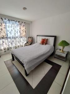 a bedroom with a bed and a table with a lamp at Habitacion privada en casa familiar con bano compartido in Armenia