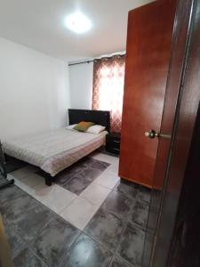 a bedroom with a bed and a wooden door at Habitacion privada en casa familiar con bano compartido in Armenia