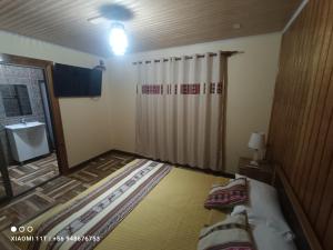 a small room with a bed and a shower at Cabañas Atahualpa in Pica