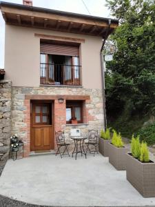 une maison avec un patio et une table devant dans l'établissement El Arniu, à Cangas de Onís