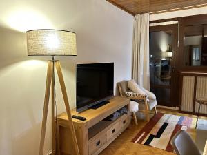 a living room with a flat screen tv and a lamp at Appartement d'une chambre a Uvernet Fours a 10 m des pistes avec balcon amenage et wifi in Uvernet
