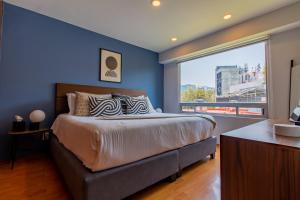 une chambre avec un grand lit et une grande fenêtre dans l'établissement Capitalia Anzures Polanco, à Mexico