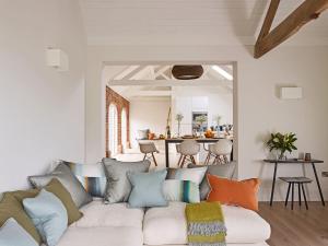a living room with a white couch with colorful pillows at The Piggery, South Courtyard in Ledbury