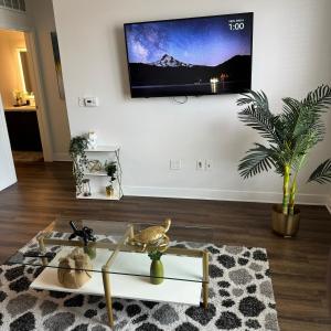 a living room with a flat screen tv on a wall at Luxury Condo with Pool & Gym ! in Glendale