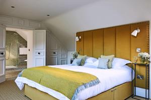 a bedroom with a large bed with a large headboard at The Millhouse in Ledbury