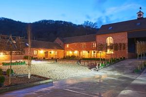 a large brick building with a courtyard at night at The Millhouse in Ledbury