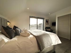 a bedroom with a large white bed with a window at Laurel Cottage in Sandown