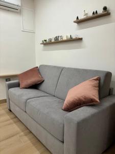 ein graues Sofa mit zwei Kissen im Wohnzimmer in der Unterkunft Casa Milù in Castellammare di Stabia