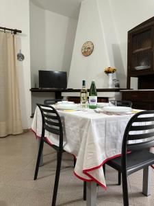 a dining room table with two chairs and a white table cloth at Gli ulivi -Appartamento al centro in Cala Gonone