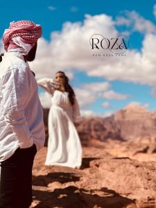 a man and a woman standing on top of a mountain at Rum Roza luxury camp in Wadi Rum