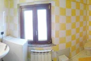 bagno con lavandino, servizi igienici e finestra di House White Apartments a Àrbatax