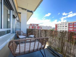 - un balcon avec deux chaises et un banc dans un bâtiment dans l'établissement Suite Helena, à Villeurbanne