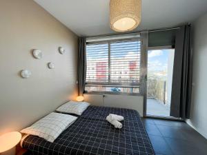 a bedroom with a bed and a large window at Suite Helena in Villeurbanne