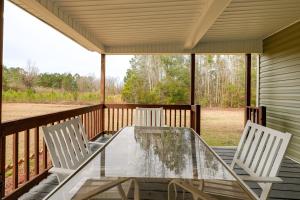 a screened porch with a glass table and two chairs at Peaceful Delco Family Home with Private Deck! 