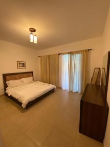 a bedroom with a bed and a television in it at شقة مطلة على بركة سباحه in Al Burj