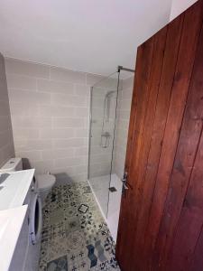 Łazienka z prysznicem i drewnianymi drzwiami w obiekcie APARTAMENTO SON BOU w Son Bou