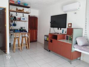 a living room with a tv and a kitchen with a table at Villa Akbal with private pool in Bacalar