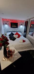 a bedroom with a bed with a table with a vase of flowers at Apartament z Jacuzzi in Kołobrzeg