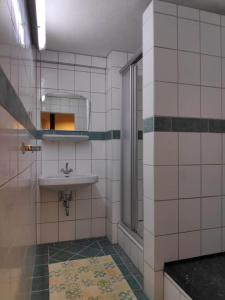 La salle de bains est pourvue d'un lavabo et d'un miroir. dans l'établissement Große 130 m2 gemütliche Wohnung im Herzen Tribergs, à Triberg