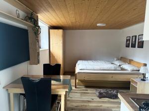 a bedroom with a bed and a desk and a table at Ferienwohnung Becker in Dalaas