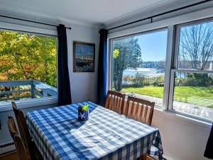 a dining room table with a blue and white checkered table cloth at Beachy Watering Cove Cottage NEW in Prospect Harbor