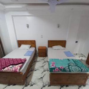 dos camas sentadas una al lado de la otra en una habitación en Fares Guest House, en Luxor