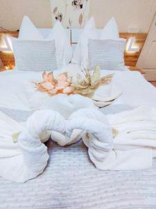 Una cama blanca con un corazón hecho de toallas en Lavender Vendégház Kicsi falu nagy szívvel varázslatos légkörrel, en Golop