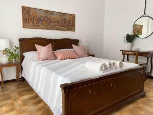 a bedroom with a bed with white sheets and pink pillows at Casa Dolci Rodolfo large bright apartment 4km to Seaside in Montemarciano