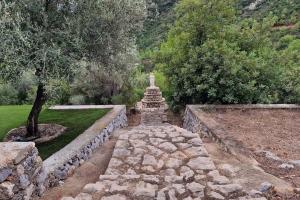 uma parede de pedra com uma estátua num jardim em casa en un parque natural em Las Villas