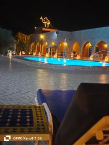 a resort with a swimming pool at night at Hotel Riad Ali in Merzouga