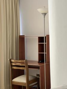 Cette chambre comprend un bureau avec une chaise et une lampe. dans l'établissement Hotel Armenia Centro, à Armenia