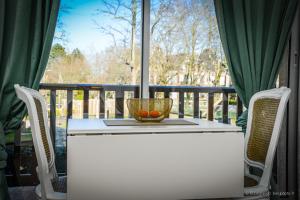 - une table blanche avec un bol de fruits sur la terrasse couverte dans l'établissement STUDIO COSY, à Cabourg