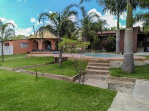 un patio con palmeras y un edificio en KALIYANGILE GUEST HOUSE, en Lusaka