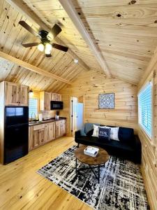een woonkamer met een zwarte bank en een keuken bij 2 Bedroom Log Cabin on Lake James with Loft- Private Resort Amenities in Marion