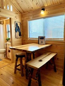 een houten kamer met een tafel en banken in een hut bij 2 Bedroom Log Cabin on Lake James with Loft- Private Resort Amenities in Marion