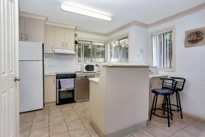 a kitchen with white cabinets and a white refrigerator at Booner Street Townhouse in Hawks Nest