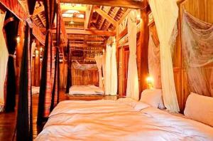 a bedroom with three beds with mosquito nets at Puluong homestay nacoLodge in Làng Chiêu