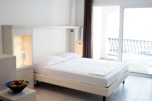 ein Schlafzimmer mit einem weißen Bett mit einem großen Fenster in der Unterkunft Apartments Casa Sul Mare in Pisak