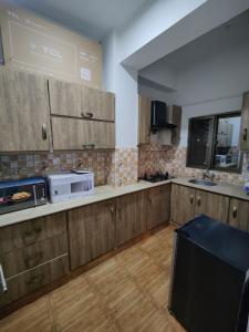 a kitchen with wooden cabinets and a microwave at 2 Bedrooms Presidential Apartment-HS Apartment in Islamabad