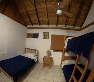 a bedroom with two beds and a ceiling fan at Hostal SoleMare in Montañita