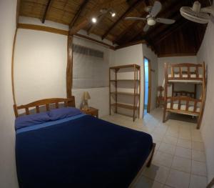 a bedroom with a blue bed and a fan at Hostal SoleMare in Montañita