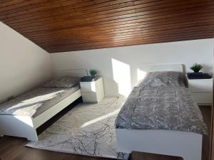 1 dormitorio con 2 camas y techo de madera en Weber Apartment Luisa, en Bohmte