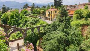 un vecchio ponte di pietra in un villaggio con alberi di Agriturismo I Cerretelli a Barga