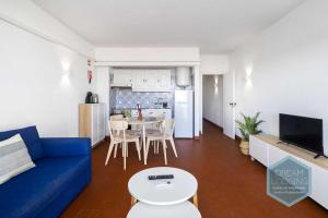 a living room with a blue couch and a kitchen at Casa Azul 714 Dream Lodging in Albufeira
