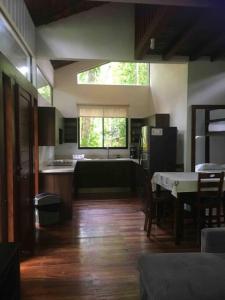 a kitchen and dining room with a table and a kitchen and a dining room at Cabaña Bosquemar 1 in Agujas