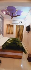 a bedroom with a ceiling fan and a bed at Shiv Niketan Guest House 200mtr from Shri Ram mandir in Ayodhya