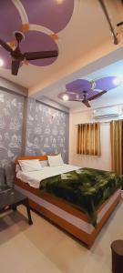 a bedroom with a bed and a ceiling fan at Shiv Niketan Guest House 200mtr from Shri Ram mandir in Ayodhya