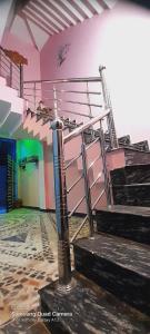 a spiral staircase in a room with a pink wall at Shiv Niketan Guest House 200mtr from Shri Ram mandir in Ayodhya