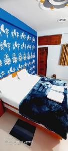 a bedroom with a bed with a blue wall at Shiv Niketan Guest House 200mtr from Shri Ram mandir in Ayodhya